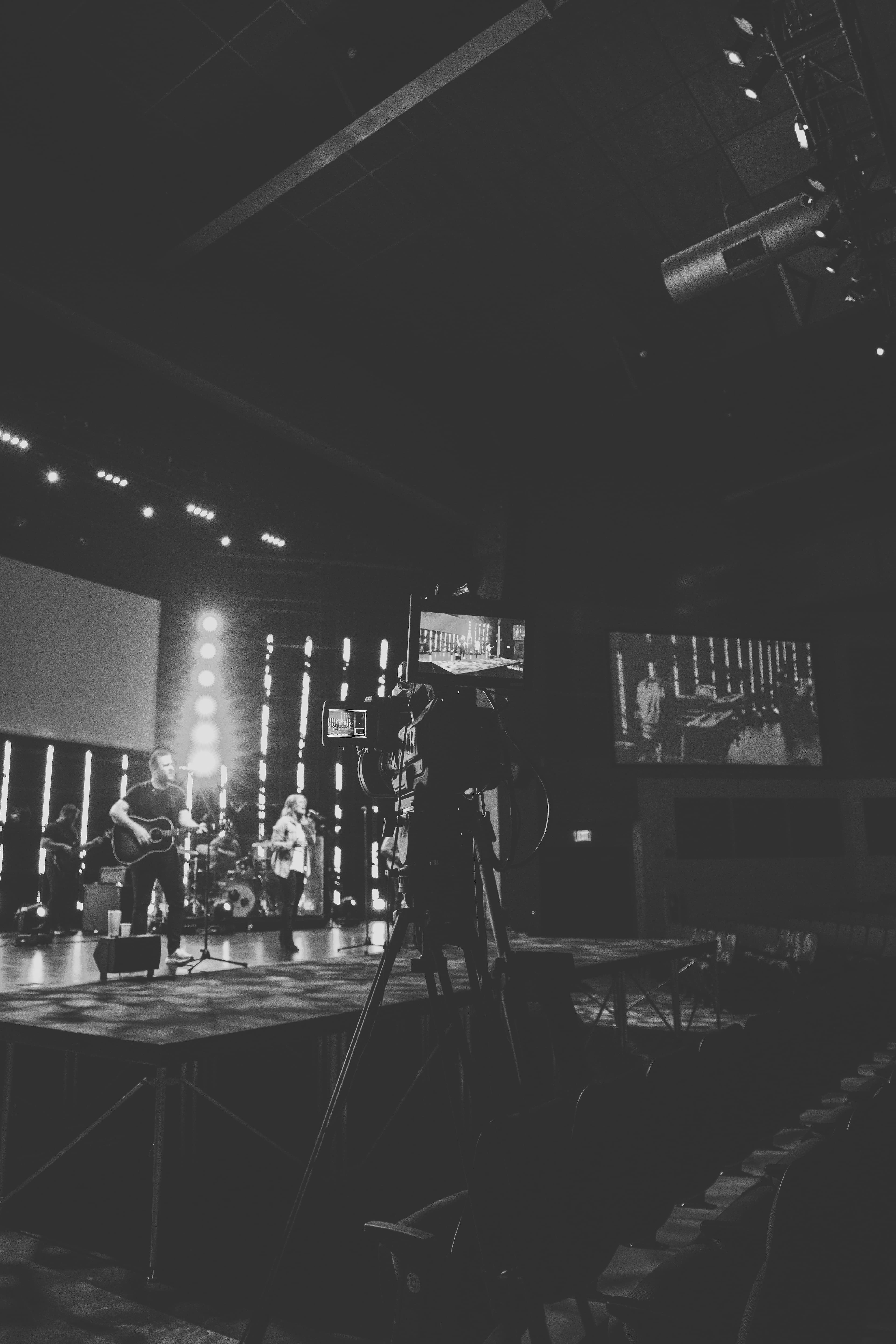 Professional photographer with DSLR camera capturing event in dimly lit venue